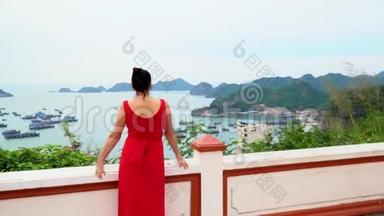 穿着红色裙子的女人花了一个时间回到镜头前，看着越南的一个海湾。 海湾的美丽景色。 <strong>猫王</strong>